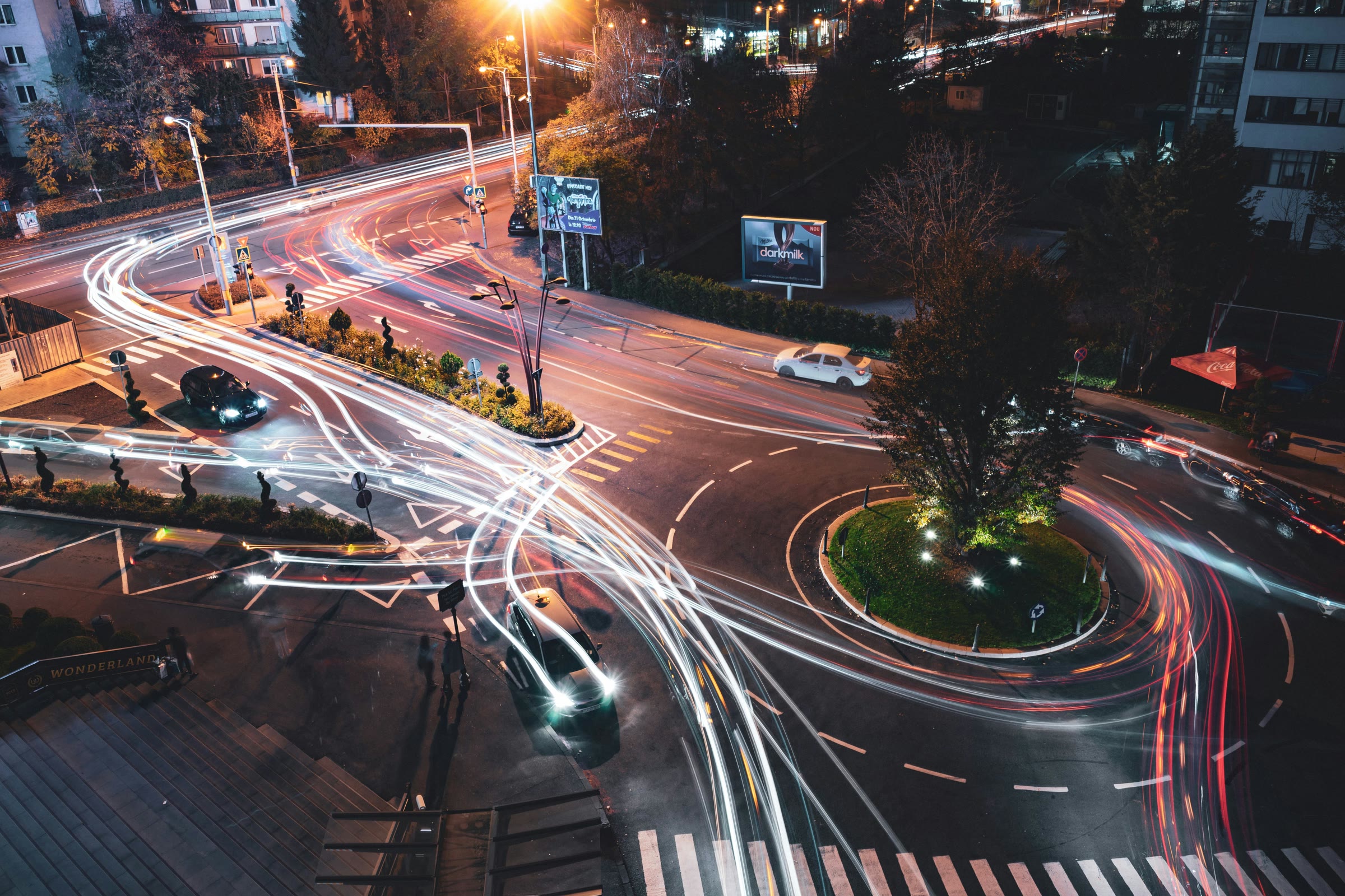Elevated night view of a city intersection with vehicle light trails
